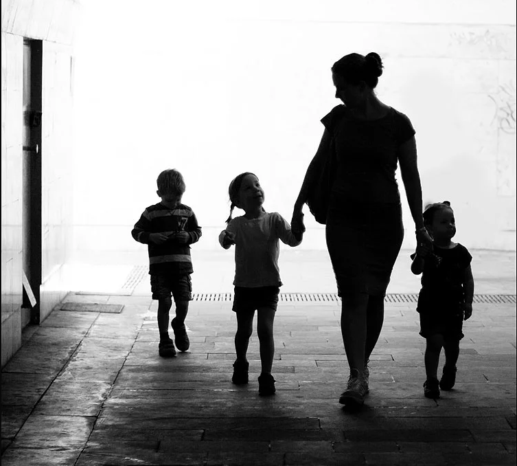 Одинокая женщина с ребенком. Мама с четырьмя детьми. Грустная семья. Женщина с четырьмя детьми.